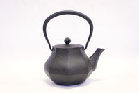 南部鉄器の鉄瓶 みやび 黒 0.4L―面取りされた胴と八角形の蓋、弧を描く持ち手を正面から