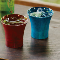 山中漆器のロックカップ クールカップ―窓辺の卓に赤と青の2客。氷と炭酸を注いだところ